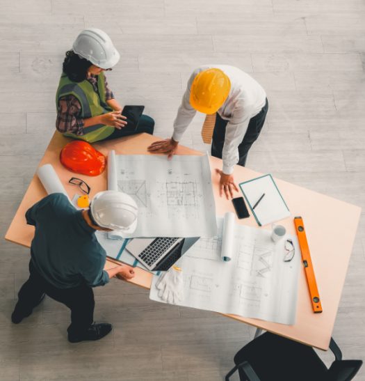 Team of engineers and architects working, planing, measuring layout of building blueprints in construction site. top view